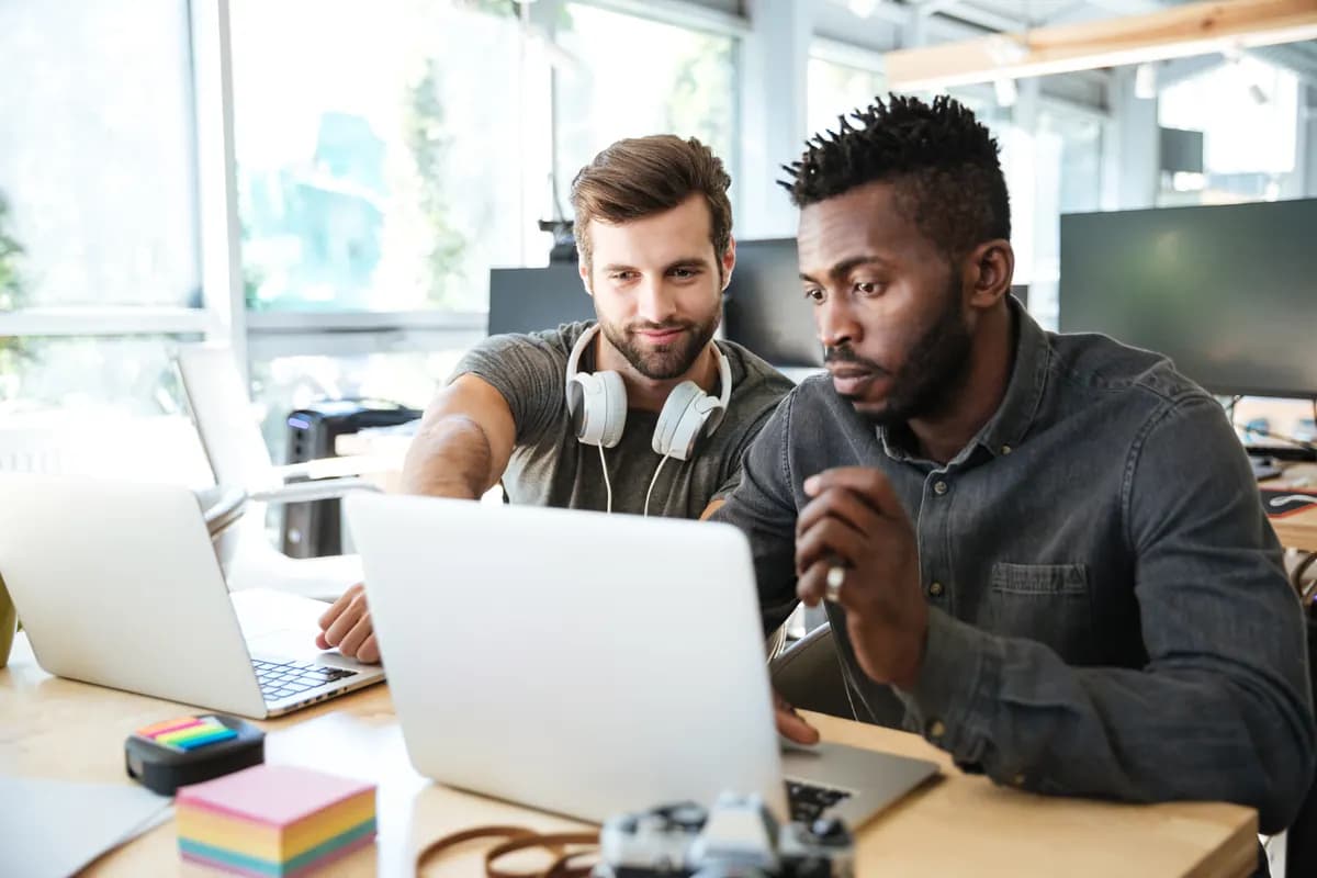A software startup team reviewing their product together on a laptop