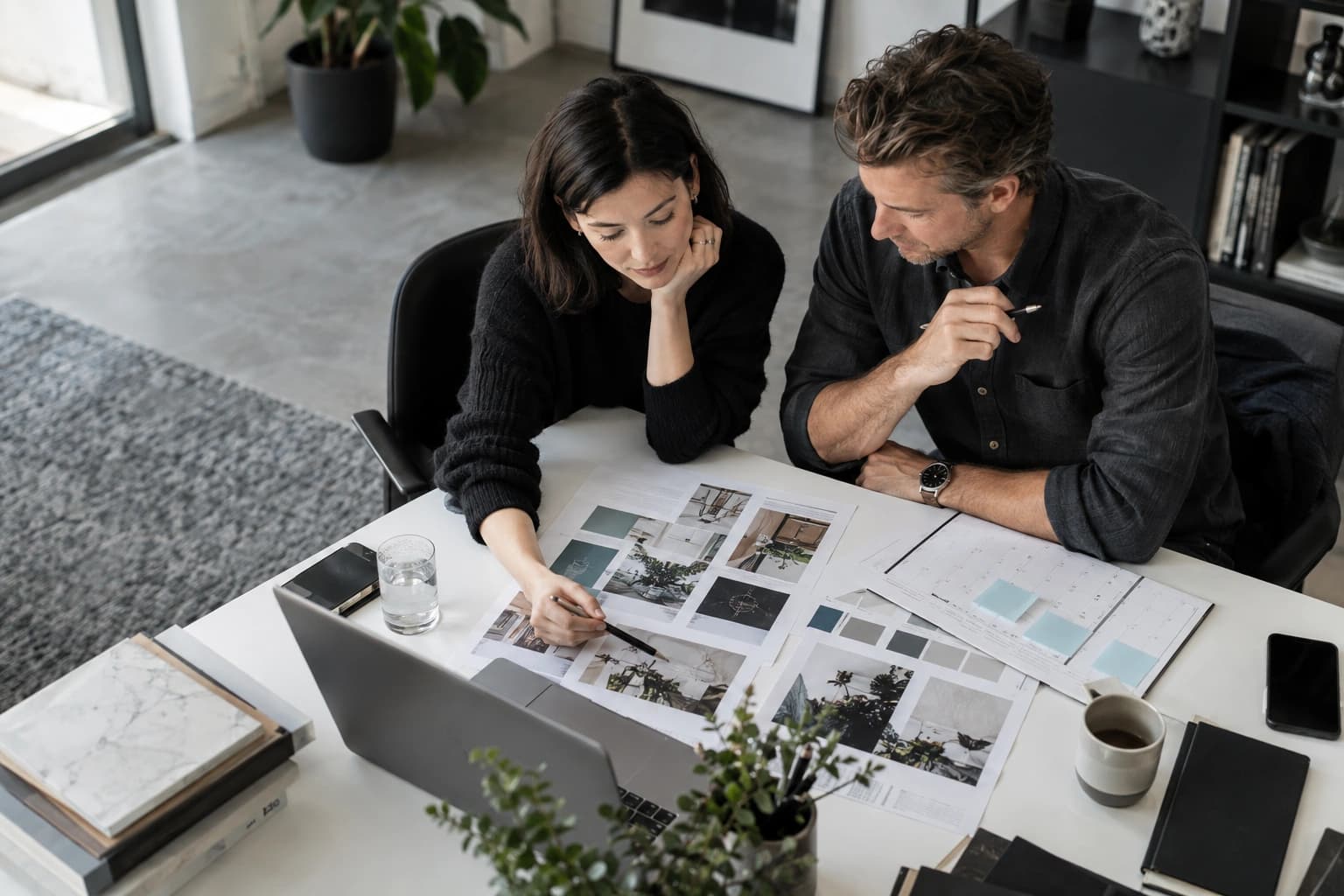 Marketing lead and designer reviewing campaign layouts and a channel calendar