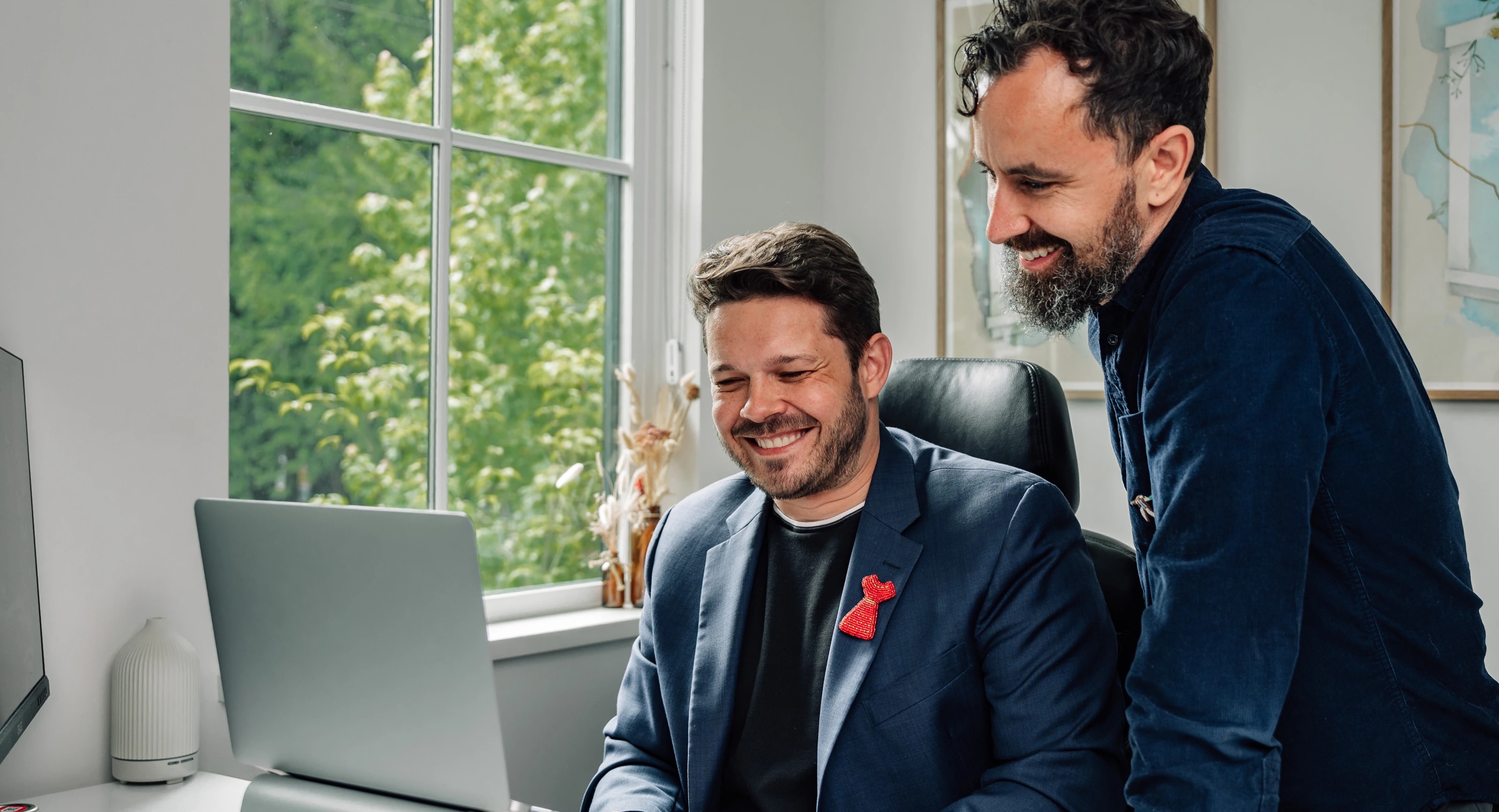 Two professionals reviewing a website project together at a desk in a bright, modern office