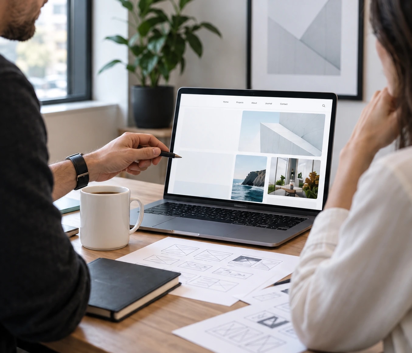 Illustrative scene of collaborators reviewing a website on a laptop with printed design wireframes